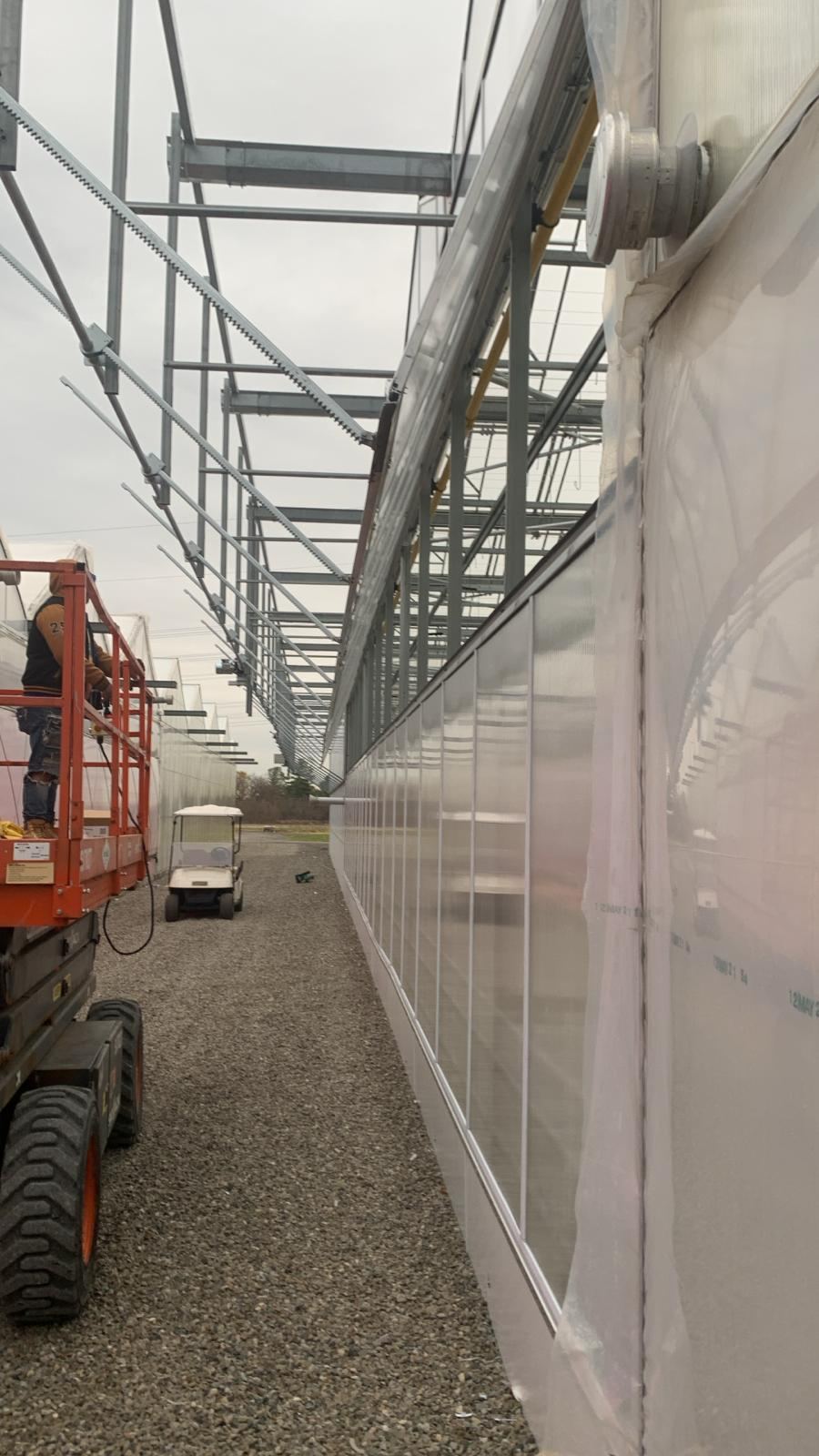 Long exterior corridor along a commercial greenhouse poly wall
