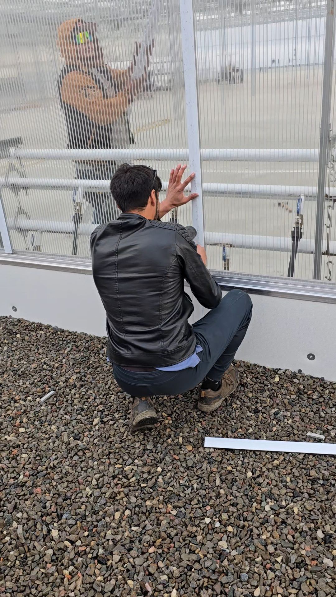 Crew fitting polycarbonate panel into frame
