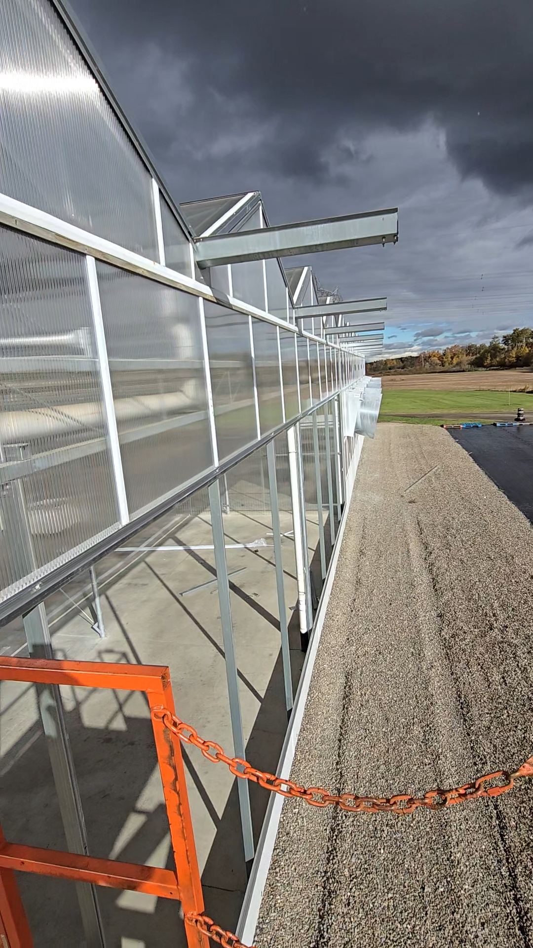Exterior polycarbonate wall under a dramatic stormy sky