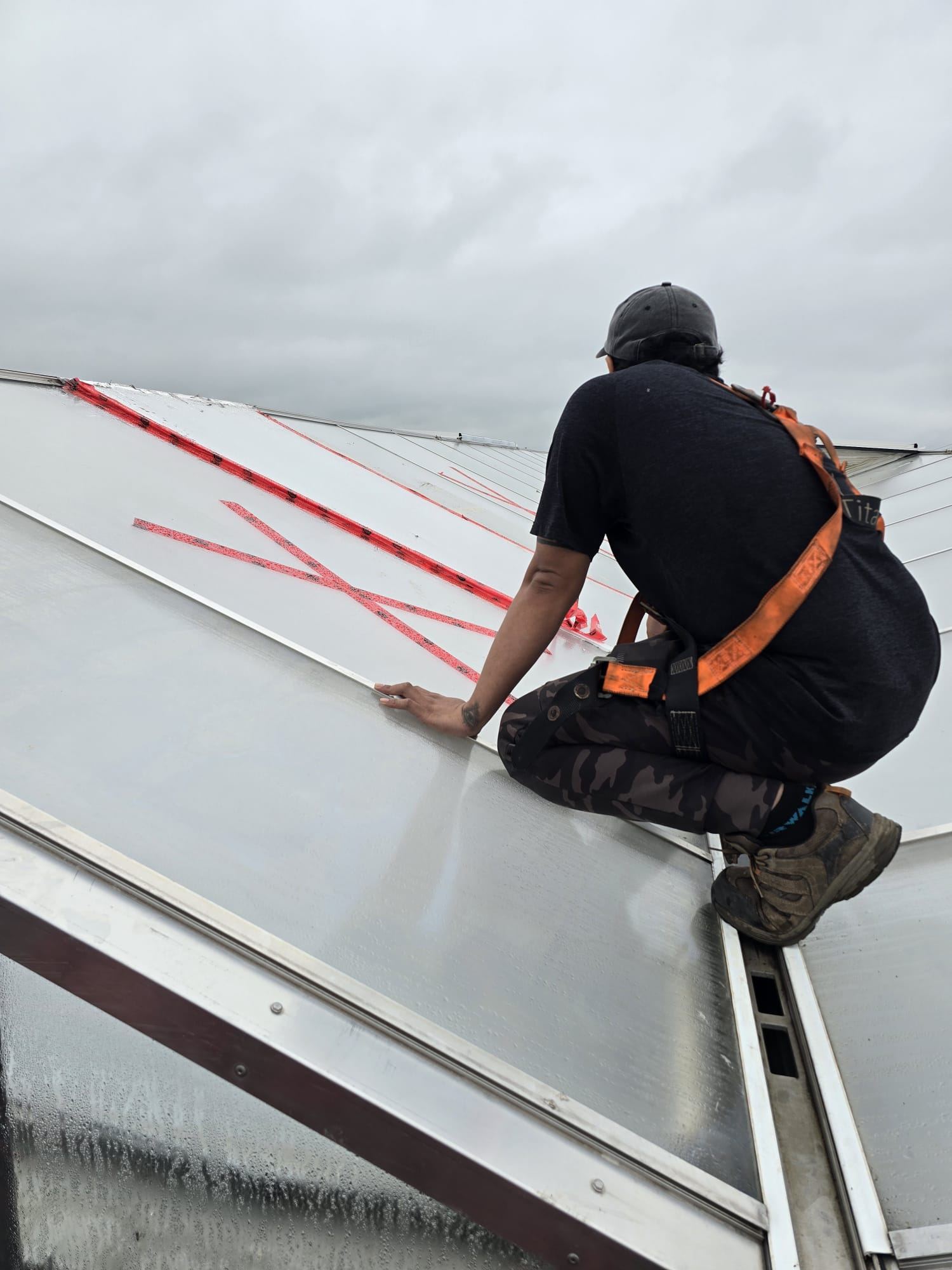 Crew inspecting and taping roof panel seams