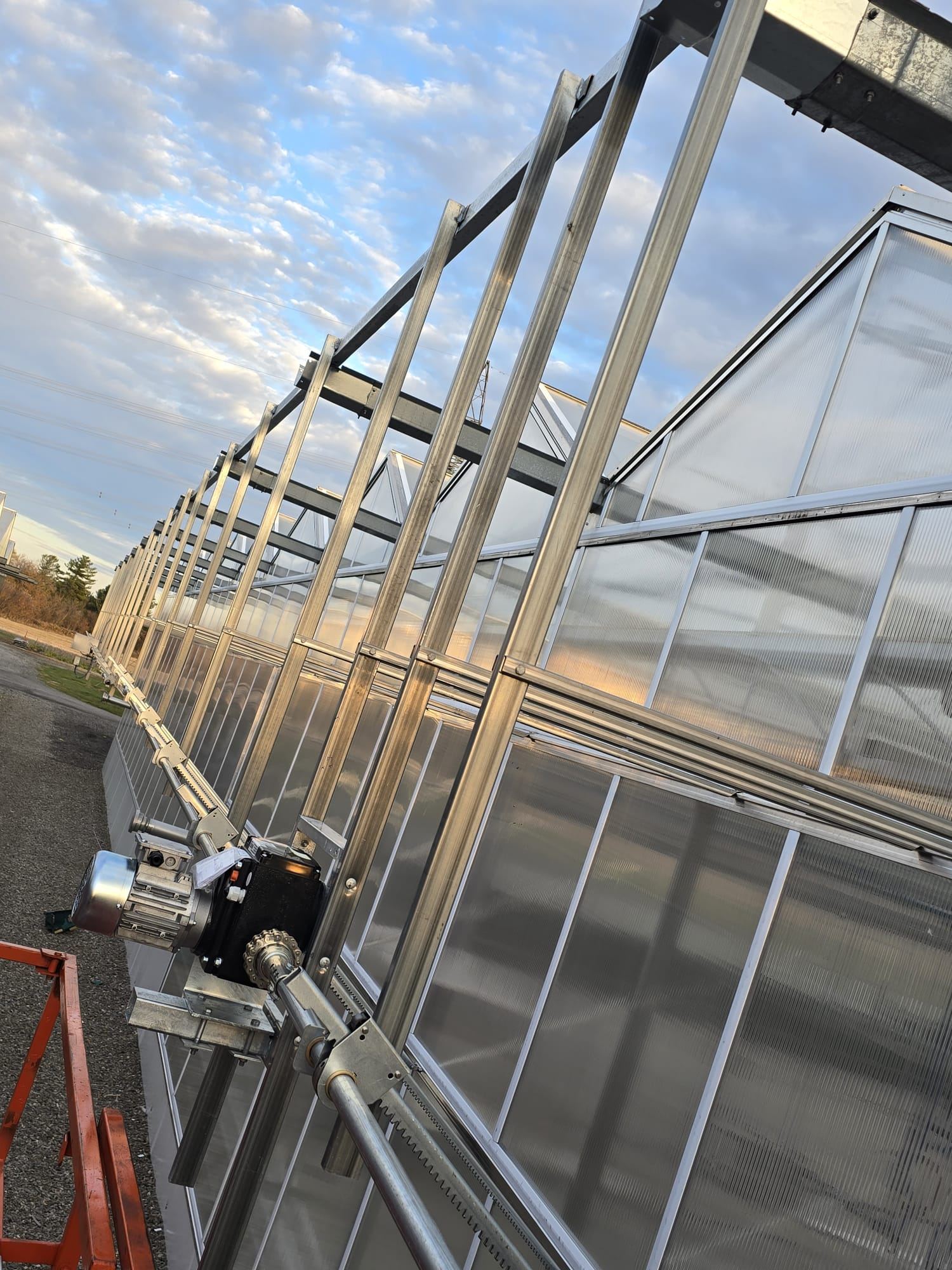 Screening system drive mechanism mounted on greenhouse exterior