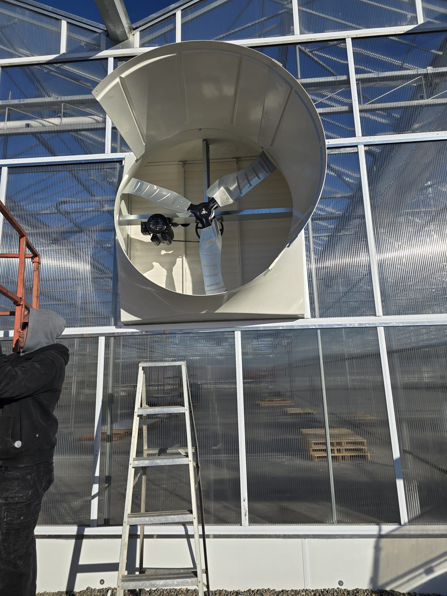 Close-up of a large exhaust fan installed on a commercial greenhouse