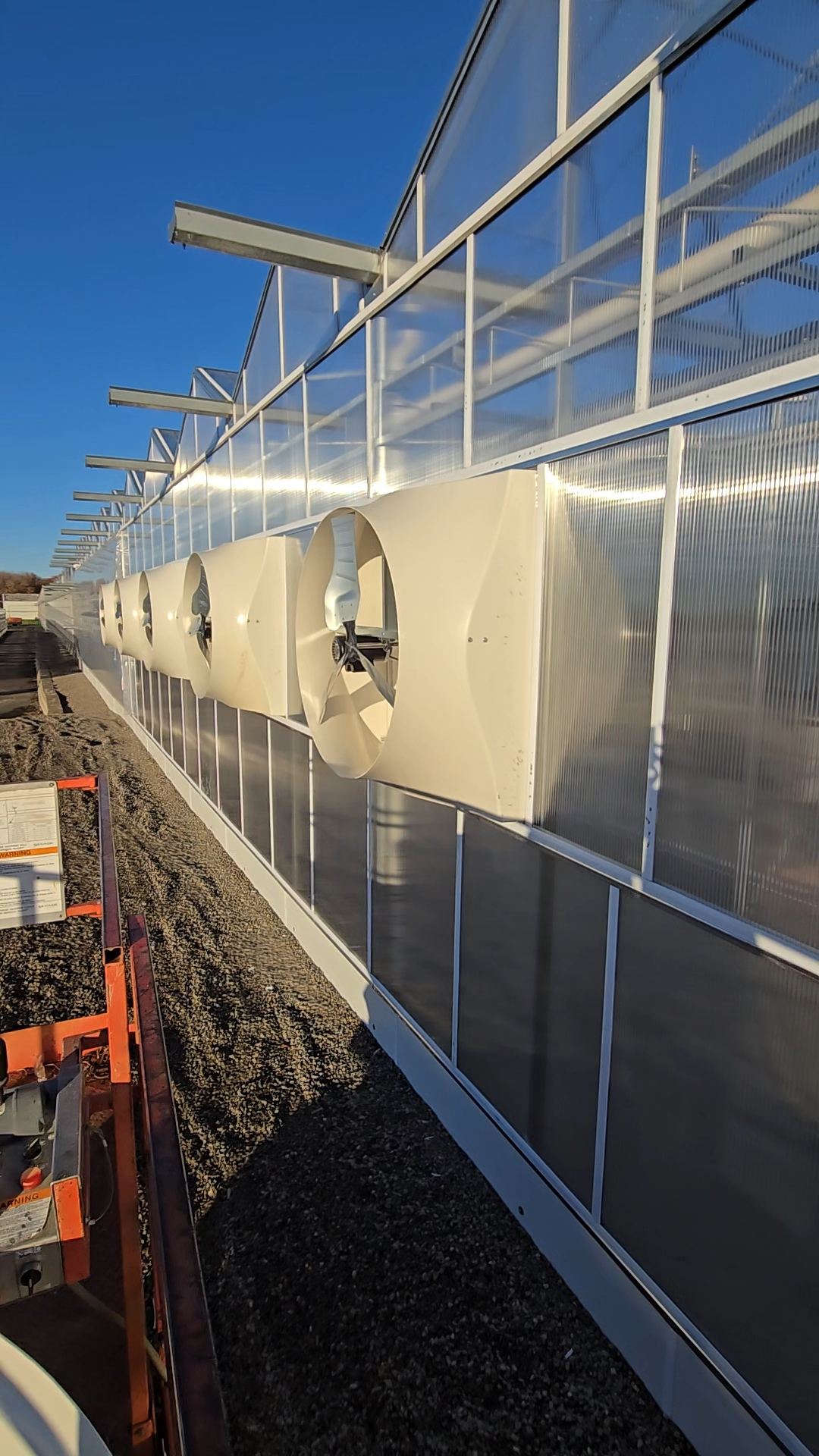 Exhaust fan ventilation system installed on greenhouse exterior wall