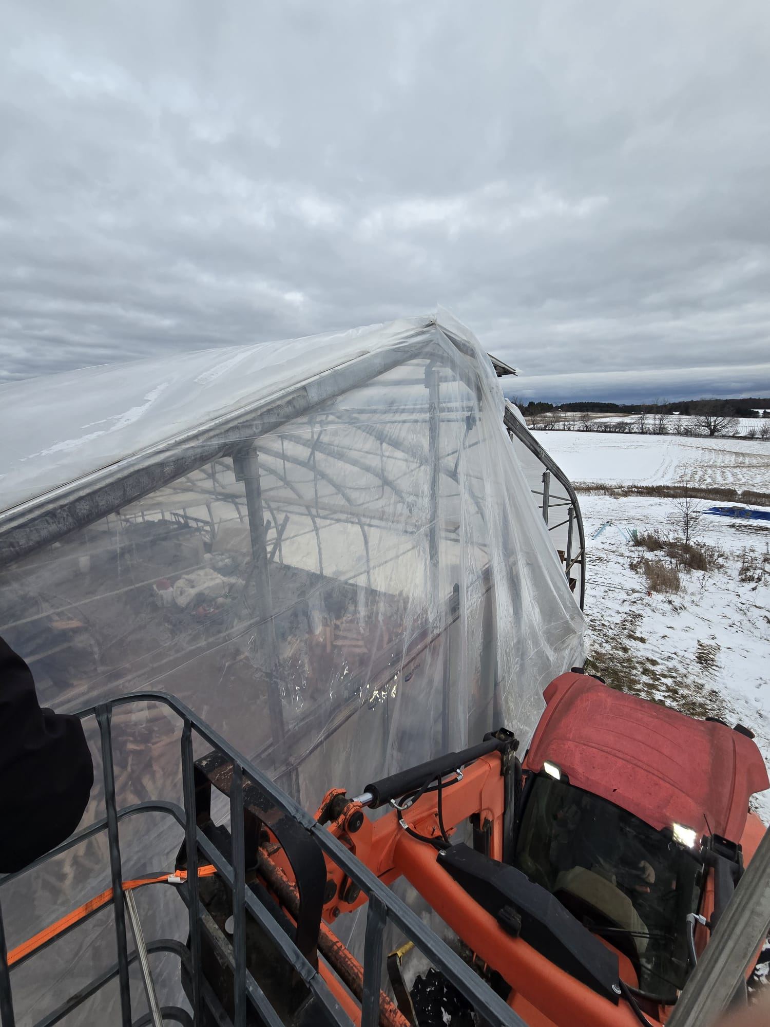 Lift crew working on a poly-covered structure in winter